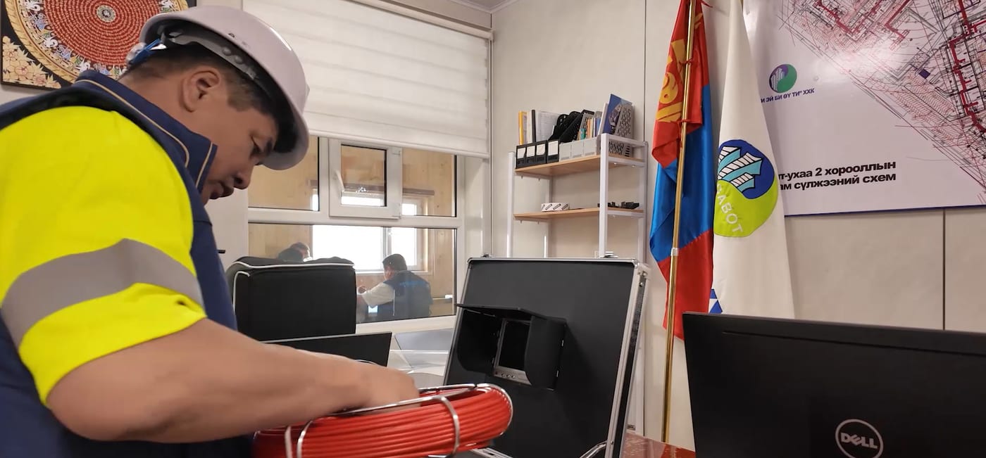 Хамгаалалтын хувцас өмссөн мэргэжилтэн ажлын тоног төхөөрөмжтэй ажиллаж буй нь